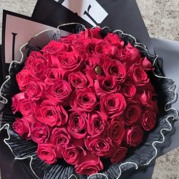 Bouquet of hot pink roses wrapped in black paper