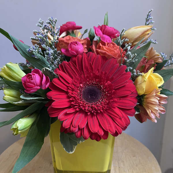 Bright mixed bouquet with a large red gerbera in a yellow vase