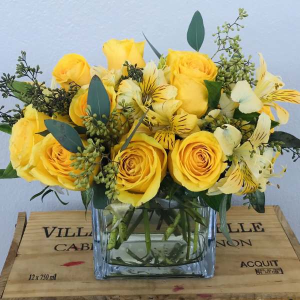 Yellow roses and alstroemeria in a clear glass vase