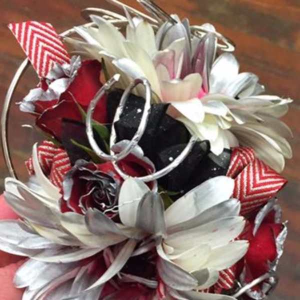 Small bouquet of white daisies and red roses with striped ribbon accents