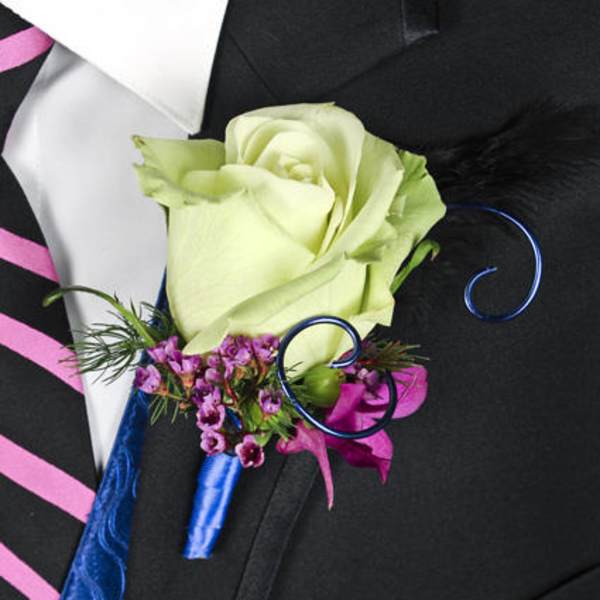 Boutonniere with a pale green rose and purple accents on a black suit