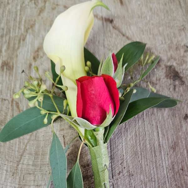 Boutonniere with a white calla lily and red rose bud