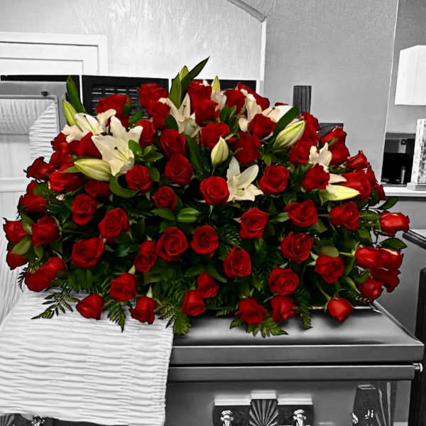 Red roses and white lilies arranged on a silver casket