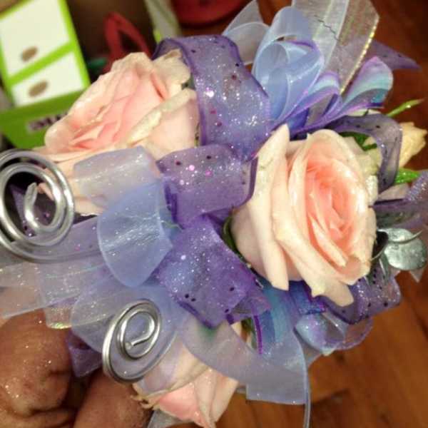 Small bouquet of pale pink roses with purple ribbon and silver spiral accents