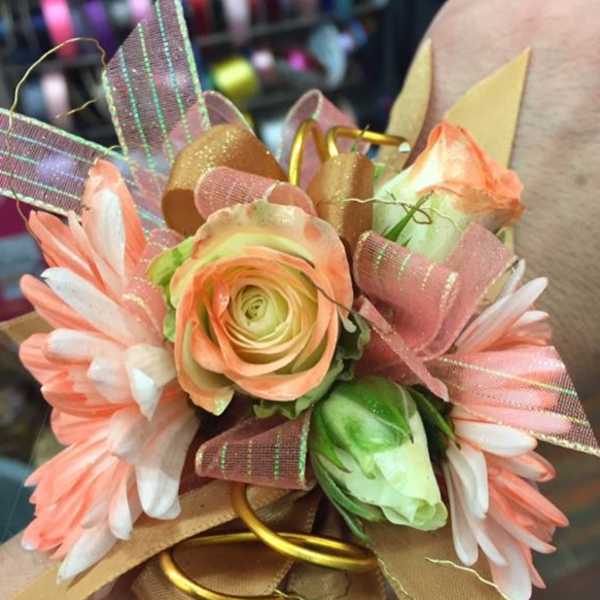 Corsage with peach and white flowers and pink ribbon