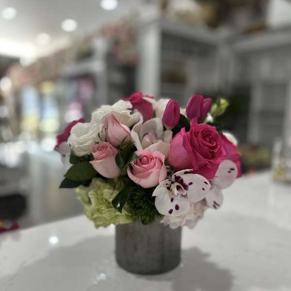 Pink and white rose bouquet in a gray vase