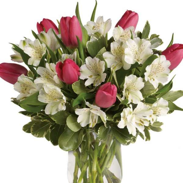 Pink tulips and white alstroemeria in a clear glass vase
