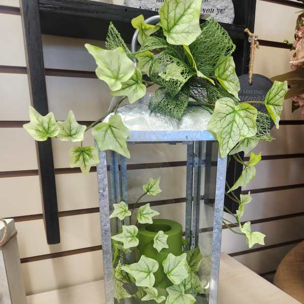Decorative lantern with green ivy and a candle inside