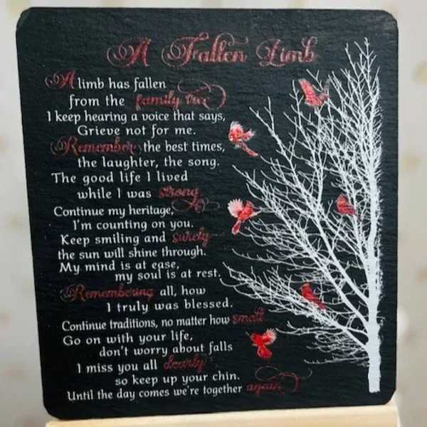 Memorial plaque with a poem and white tree graphic on a black background