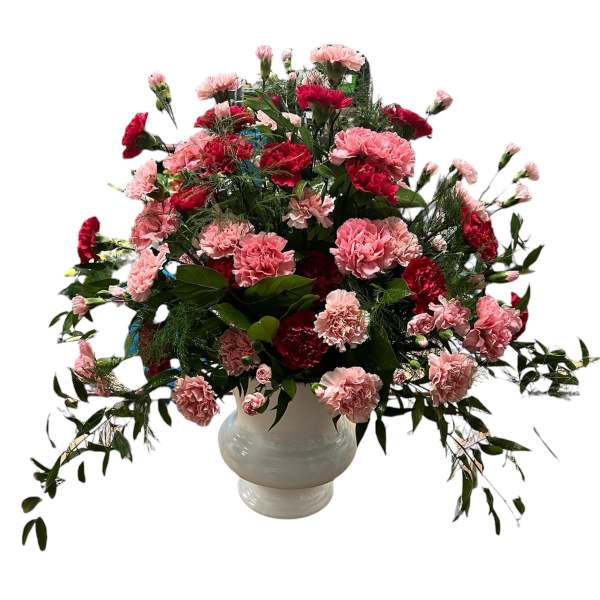 Large bouquet of pink and red carnations in a white vase