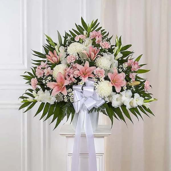 Pink and white floral standing arrangement with a white ribbon bow