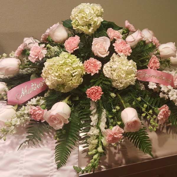 Pink and white floral casket spray with roses and carnations