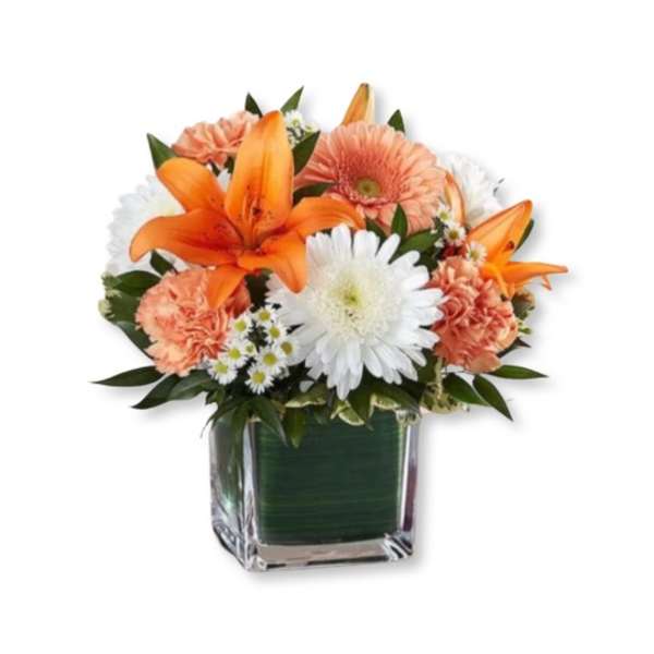 Orange lilies and white daisies in a square glass vase