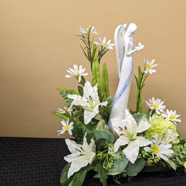 White floral arrangement with a central angel figurine