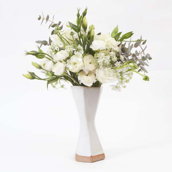 White floral arrangement in a tall white vase
