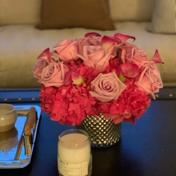 Pink rose arrangement in a textured silver vase on a table