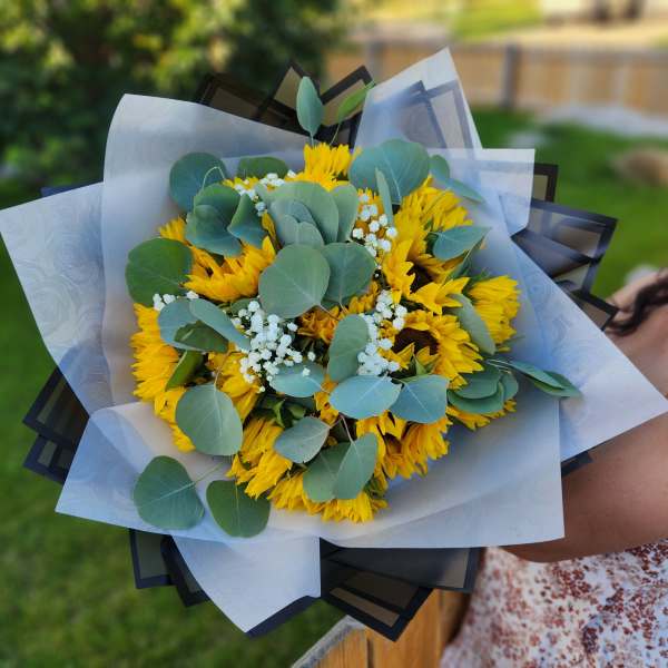 Bouquet of yellow sunflowers with eucalyptus and white filler flowers