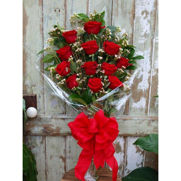 Bouquet of red roses wrapped in clear plastic with a large red bow