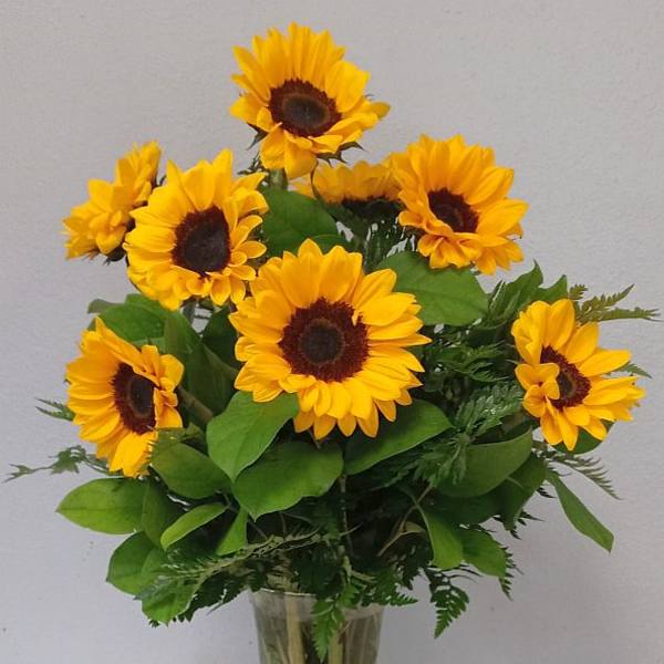 Bouquet of yellow sunflowers in a clear glass vase