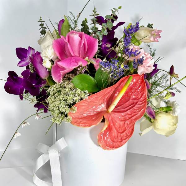 Mixed bouquet in a white hatbox with pink, purple, white, and coral blooms