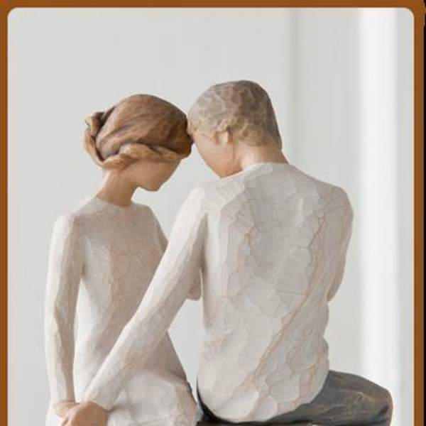 Two carved figurines of a seated couple facing each other