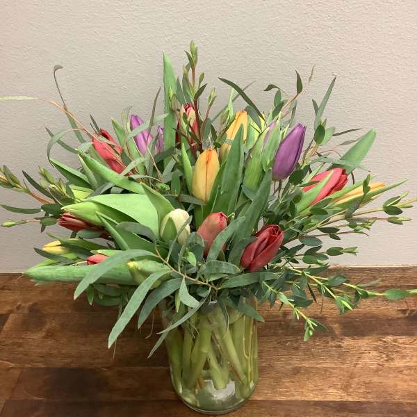 Bouquet of multicolored tulips in a clear glass vase