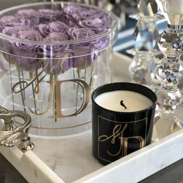 Lavender roses in a clear round box with a black candle and crystal decor