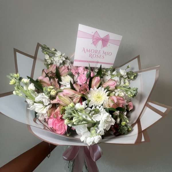 Pink and white bouquet with a ribbon and card
