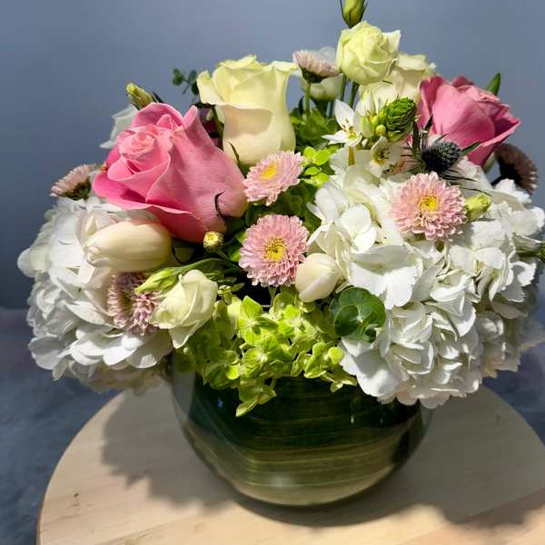 Pink and white roses with hydrangeas in a glass vase