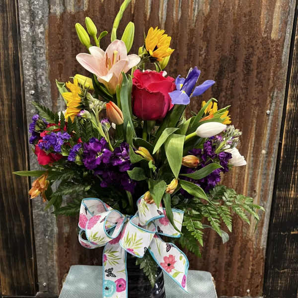 Mixed bouquet in a black vase with a floral ribbon bow