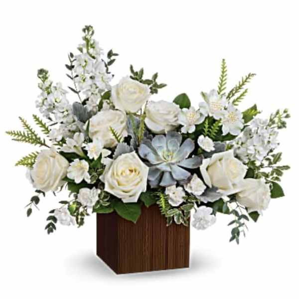 White roses and mixed white flowers in a wooden cube vase
