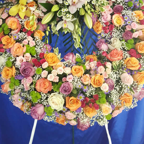 Large floral wreath with orchids and roses on a blue backdrop
