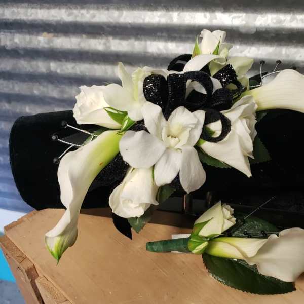 White calla lilies and orchids with black ribbon on a black cushion