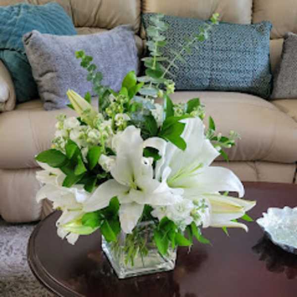 White lilies arranged in a clear glass vase