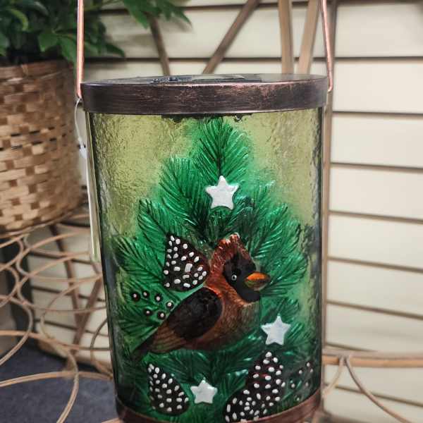 Decorative glass lantern with a painted Christmas tree and bird motif