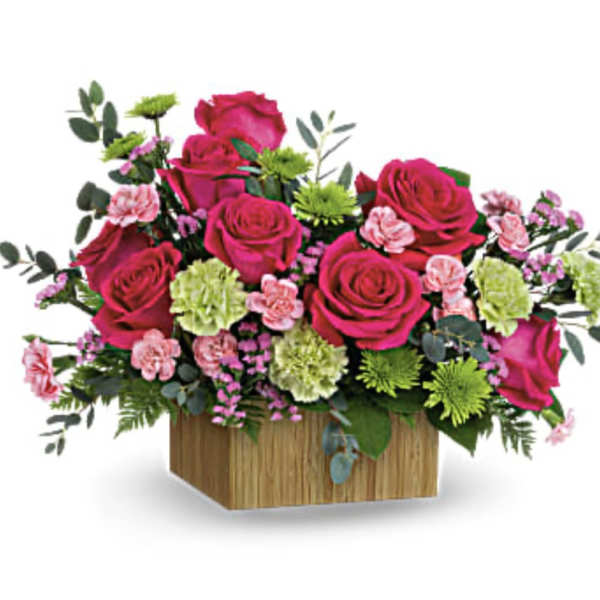 Pink roses and carnations in a wooden box
