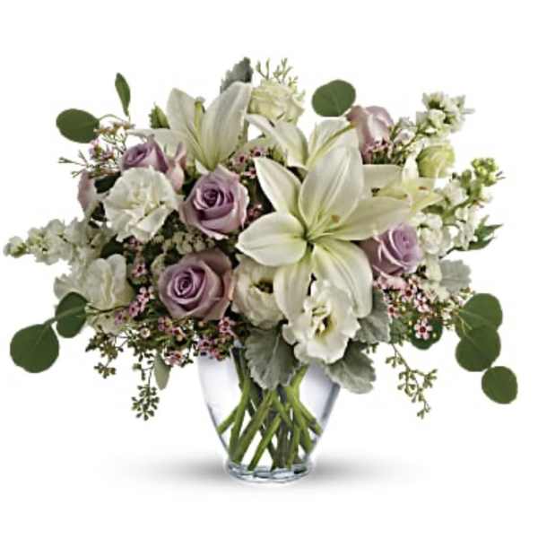 Lavender roses and white lilies in a clear glass vase