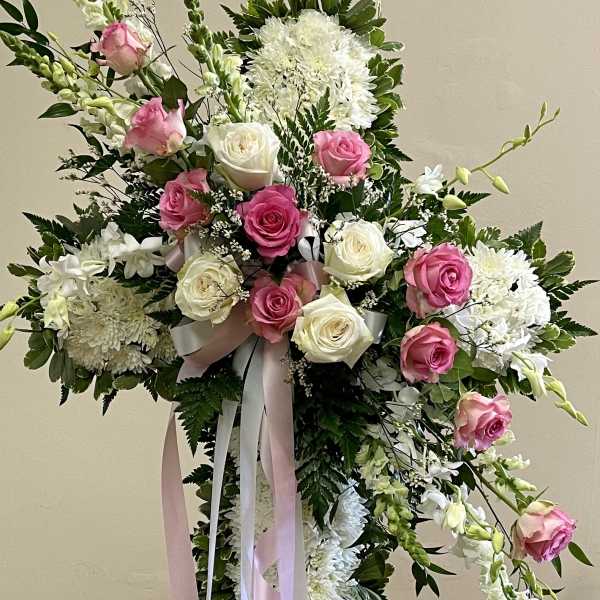 Standing floral cross with pink and white roses and white blooms