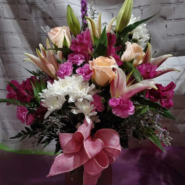 Bouquet of pink and white flowers in a vase with a pink bow