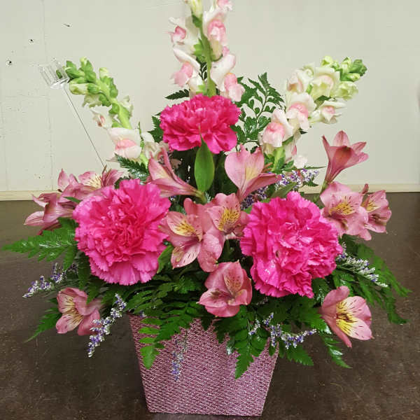 Pink and white floral arrangement in a glittery pink container
