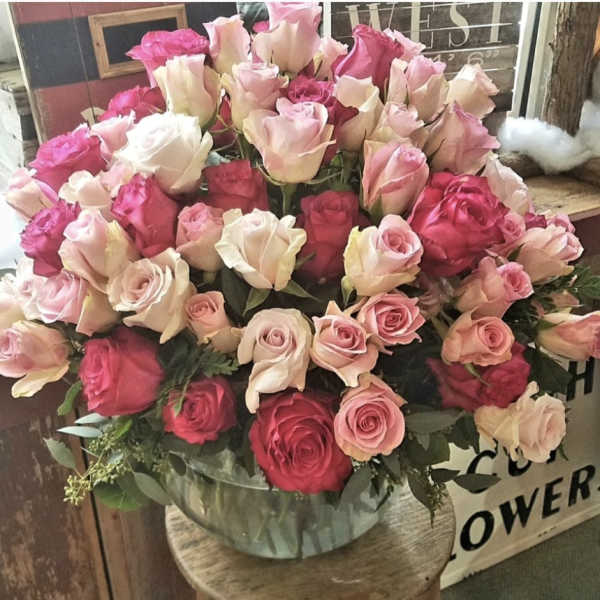 Large bouquet of pink and cream roses in a clear vase