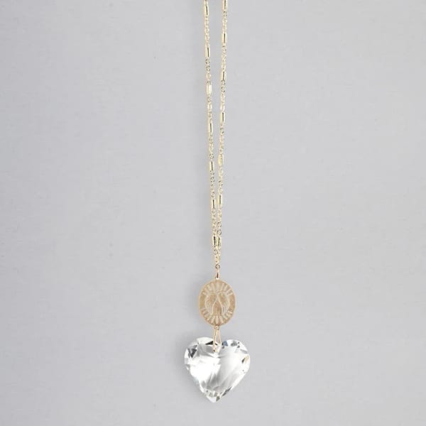 Gold chain necklace with engraved disc and clear heart-shaped crystal pendant