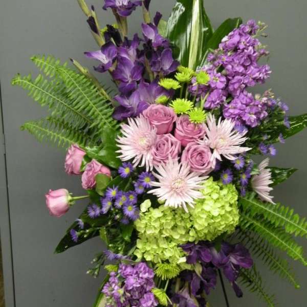 Purple and pink floral arrangement with roses, hydrangea, and tall blooms