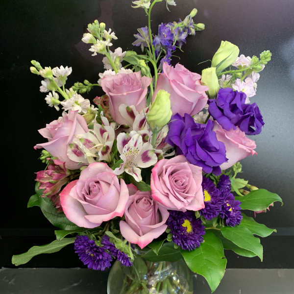 Pink and purple mixed bouquet in a clear glass vase