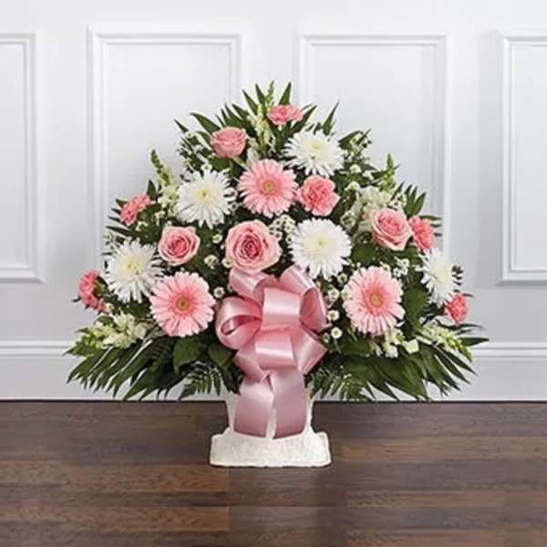 Pink and white floral arrangement with a pink ribbon in a white vase