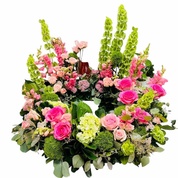 Circular floral wreath with pink roses and tall green blooms
