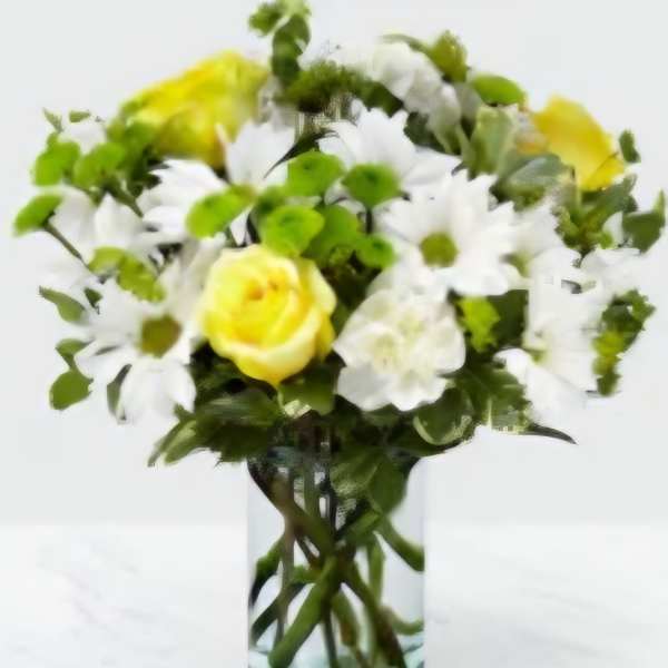 Yellow roses and white daisies in a clear glass vase