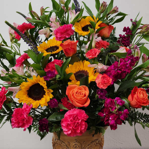 Mixed bouquet with sunflowers, roses, carnations, and alstroemeria in a vase