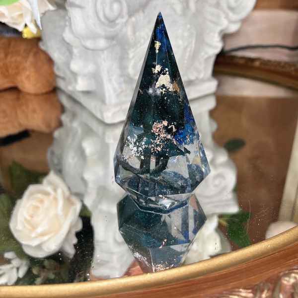 Faceted dark blue crystal ornament in front of white roses