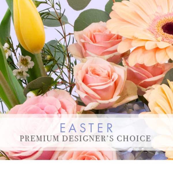 Pastel Easter arrangement with pink roses, a yellow tulip, and a peach gerbera daisy in close-up view